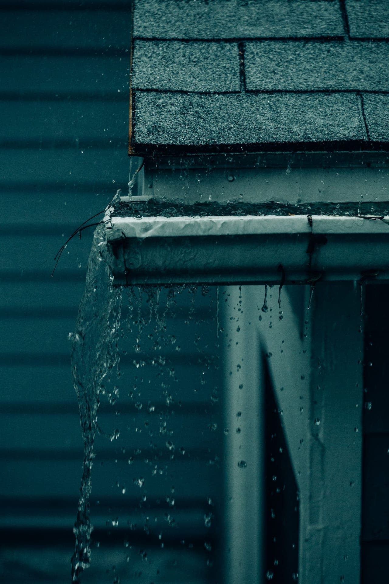 Rainwater pouring from a gutter corner